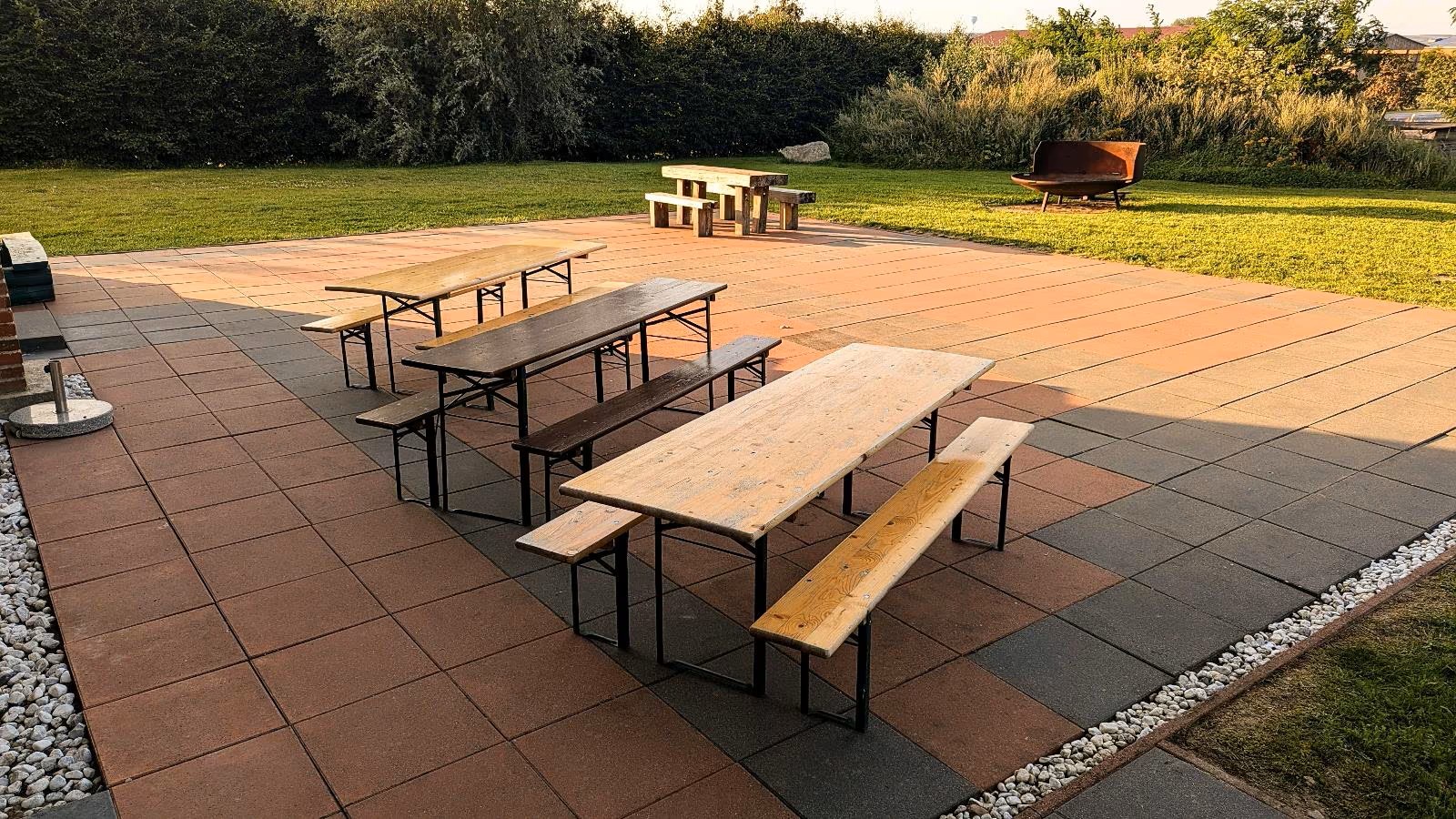 Terrasse mit Bierzeltgarnituren und Feuerschale