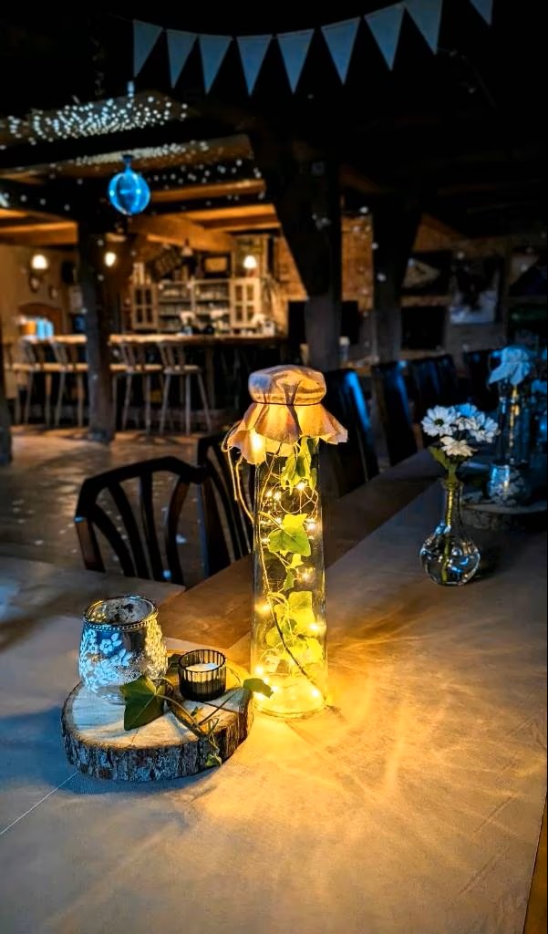 Tischdekoration mit Lichterflaschen und Blumen